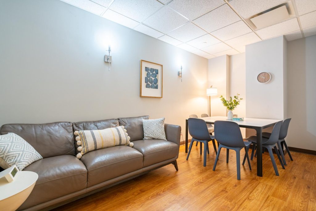 One of Brooklyn Hourly Office rentals that includes a conference table as well as comfortable sofa.